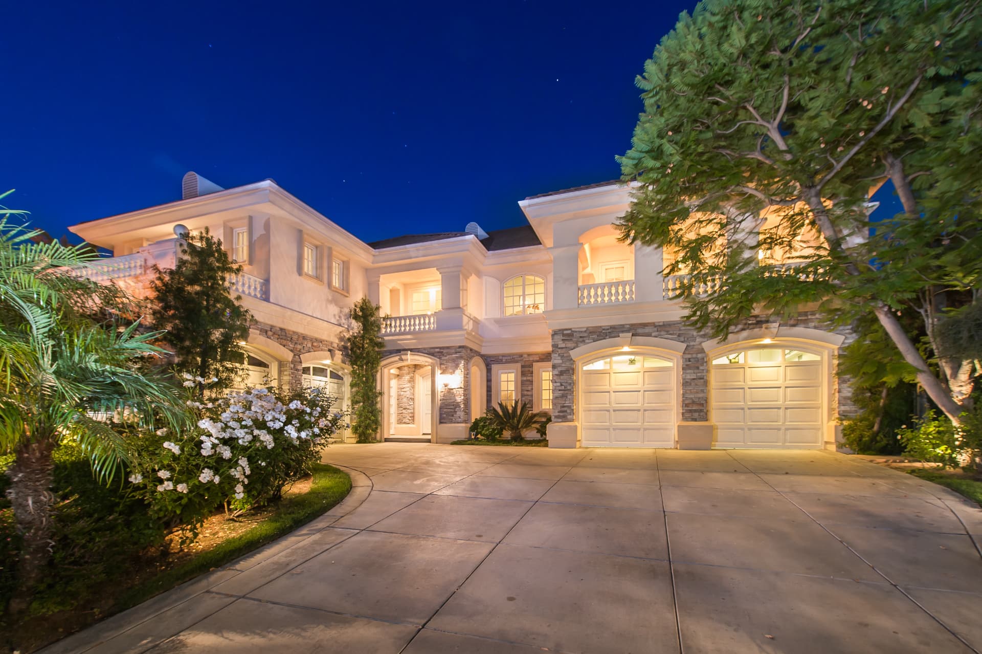Arched motor court and balconies of a Mediterranean home in Sherman Oaks at night