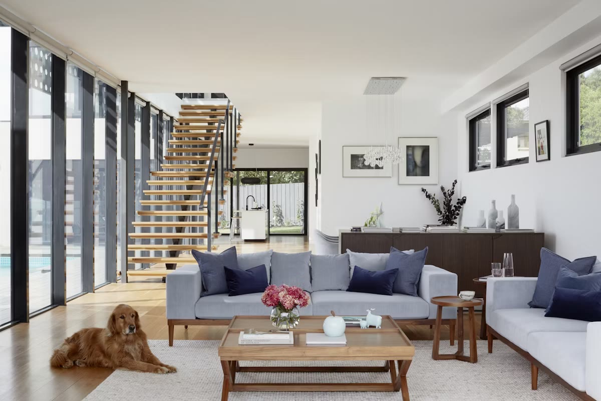 Light-filled modern living room with an open kitchen and pool views